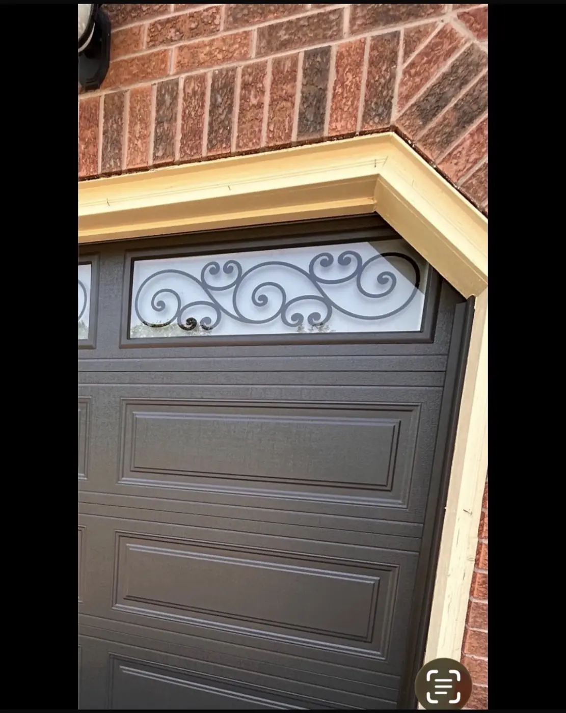 Grey garage door with decorative glass windows, one of the styles available for installation in Brampton
